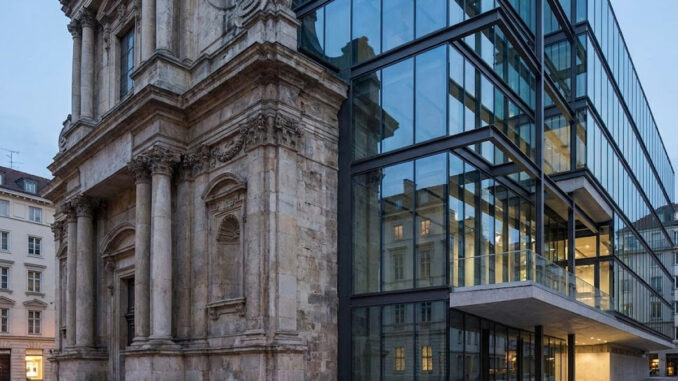 A historic stone building facade seamlessly integrated with a contemporary multi-story glass and steel architectural addition.